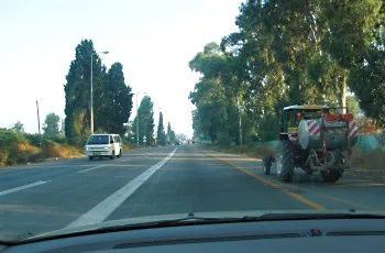 Where should vehicles drive in a road divided by a continuous white line?